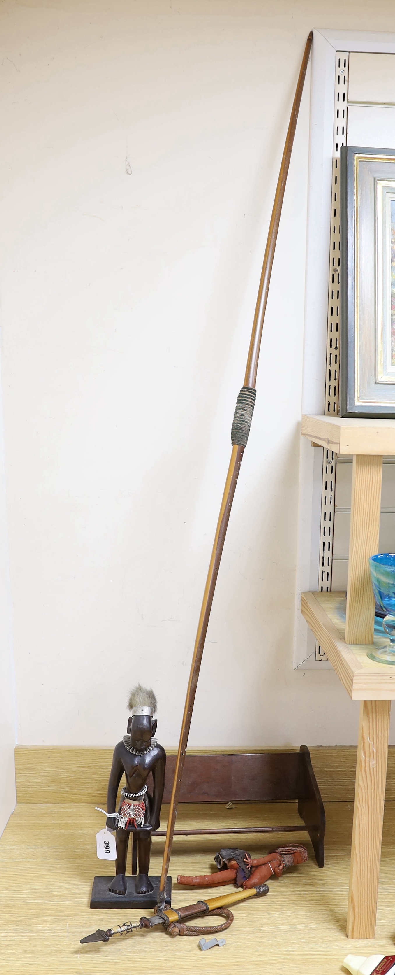 A collection of tribal items including a fabric doll, an African carved wood figure and a dagger and bow, bow 166cm long